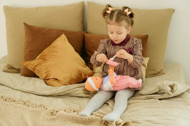 petite fille qui donne à manger à sa poupée